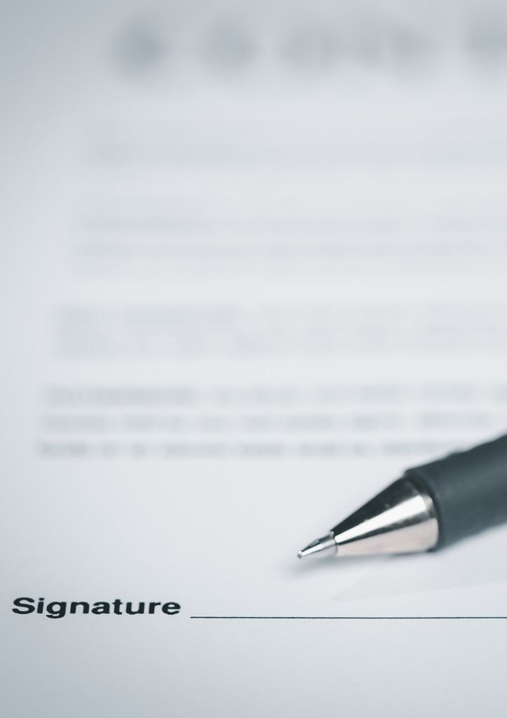 Image of a contract close up on signature and pen